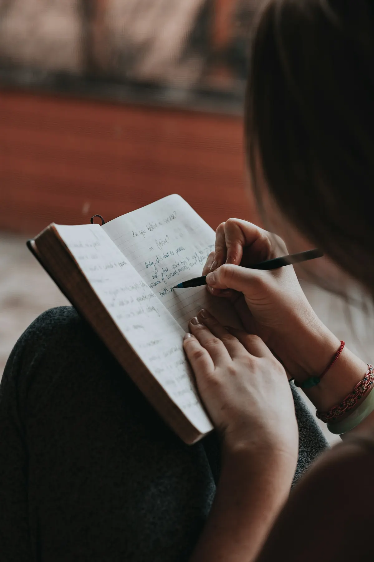 Una mano escribe en un cuaderno abierto